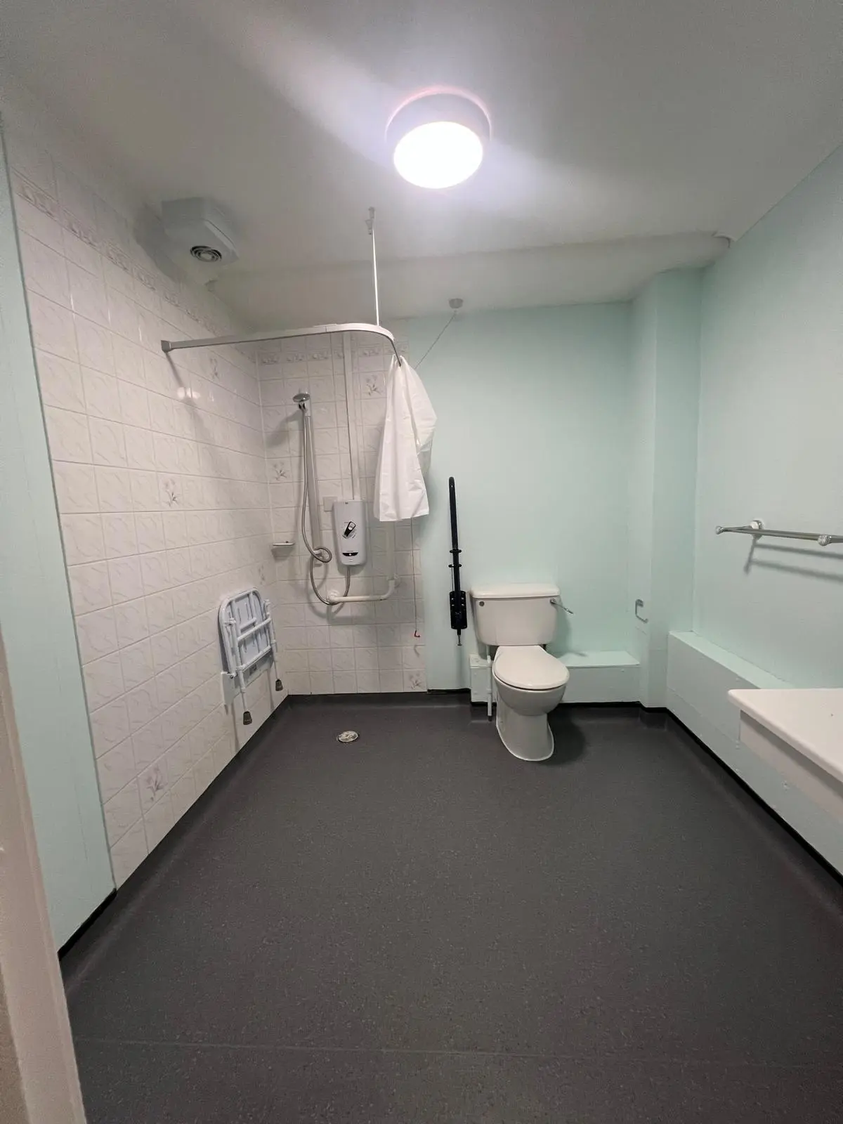 Dark non-slip bathroom flooring professionally fitted around sanitary fixtures