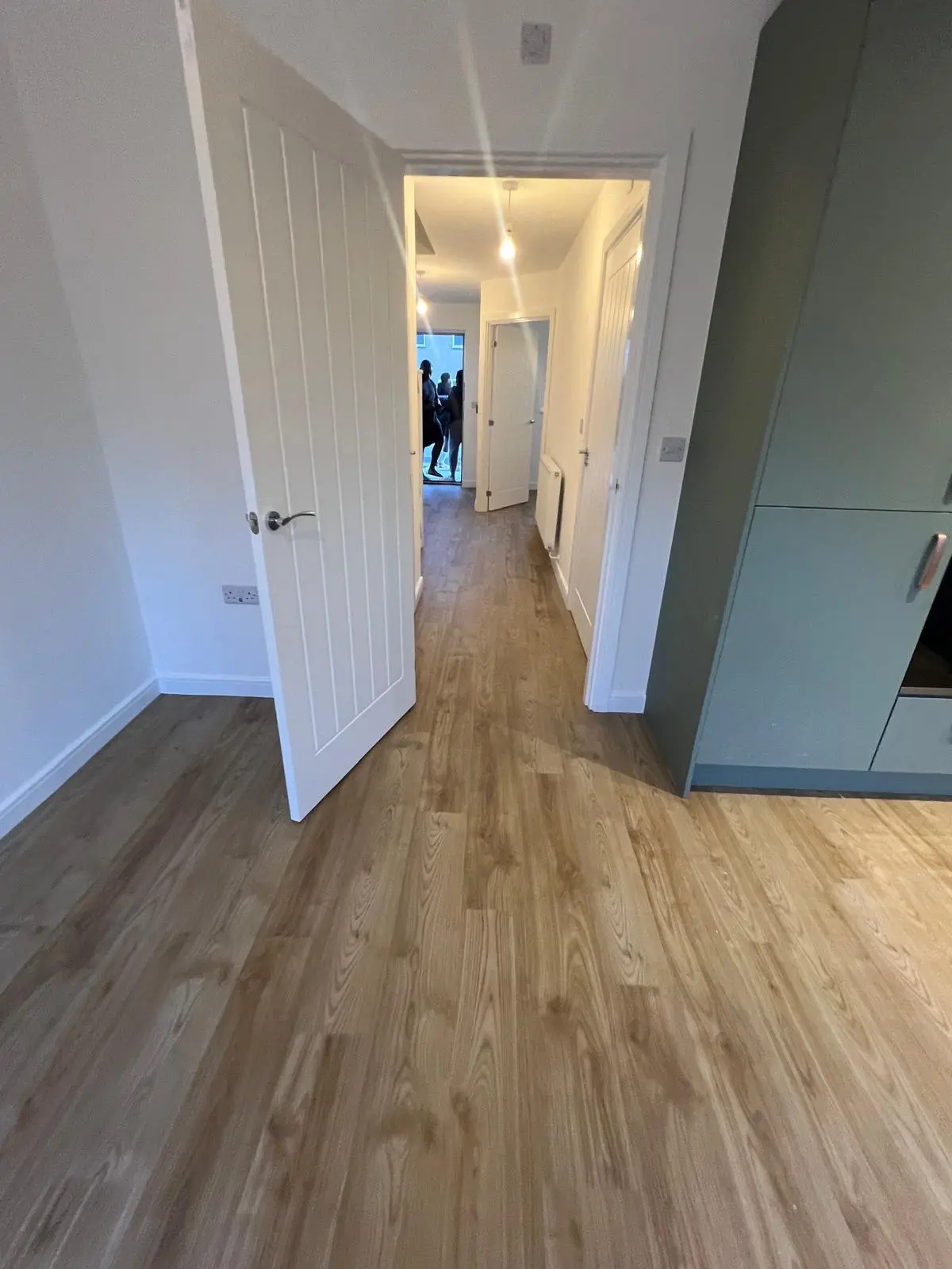 Natural oak-effect vinyl flooring fitted through a kitchen and connecting hallway